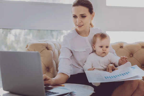 Modedesigner på moderskap lämna kontrollera hennes e-post medan innehav baby — Stockfoto