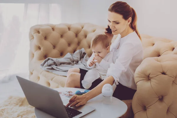 Bionda madre di lavoro contattando i clienti che giocano con la bambina — Foto Stock