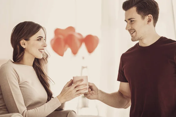 Atento novio cariñoso dando taza de café a su prometido — Foto de Stock