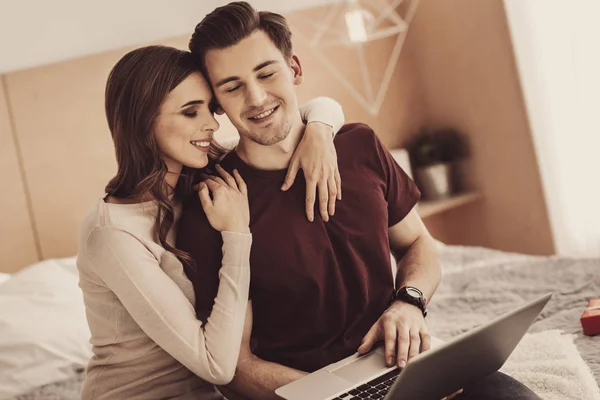 Jovens parceiros de amor sentindo-se aliviados ao olhar para fotos no laptop juntos — Fotografia de Stock