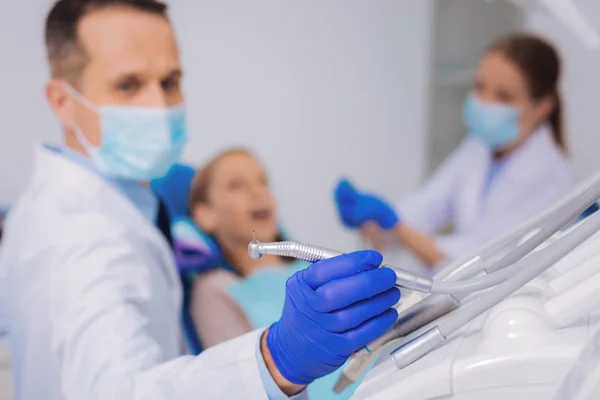 Lugn läkare tar en dental borr medan du arbetar — Stockfoto