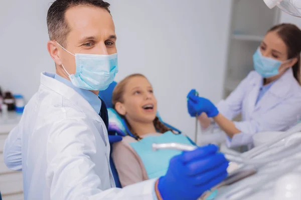 小病人微笑着, 而她的医生正在进行牙科钻 — 图库照片