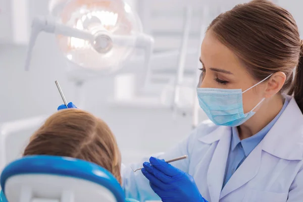 Cuidado Doctor Agradable Joven Dentista Examinando Cuidadosamente Paciente Mientras Está —  Fotos de Stock