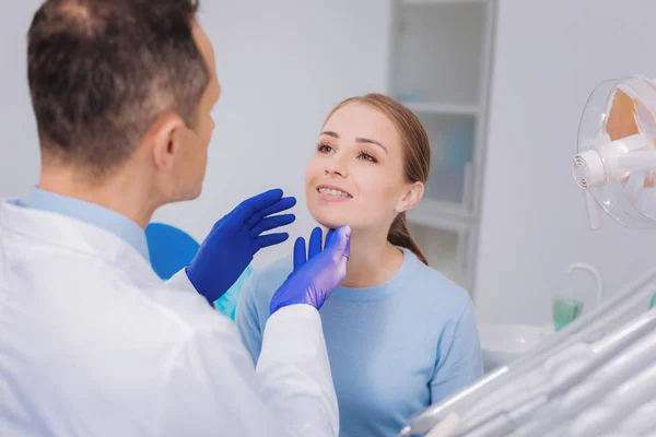 Ansvarig patienten visar hennes tänder när du besöker en tandläkare — Stockfoto