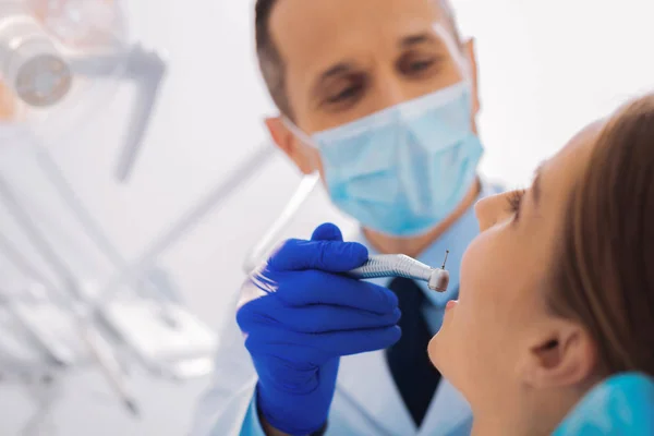 Dentiste joyeux tenant soigneusement l'équipement dentaire tout en travaillant — Photo