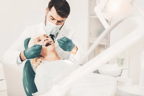 患者の検査 高齢者の感じのいい女性歯科医の椅子に座って リラックスしながらプロの歯科処置を得ること — ストック写真