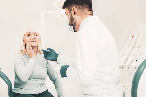 Mature lady listening to dentist — Stock Photo, Image