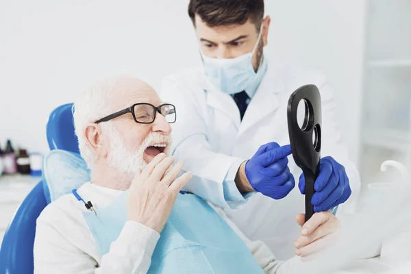 Kellemes magas rangú ember, fogorvosok munka becslése — Stock Fotó