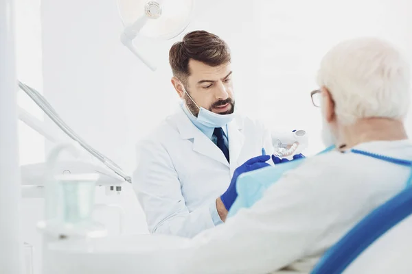 Serio mężczyzna Dentyści wyjaśniający szczegóły — Zdjęcie stockowe