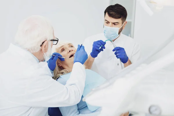 Ervaren mannelijke tandartsen behandeling van patiënt — Stockfoto