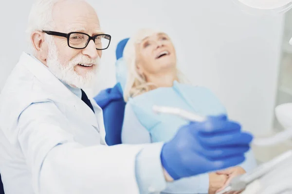 Instrumento de acaparamiento de dentista masculino alegre — Foto de Stock