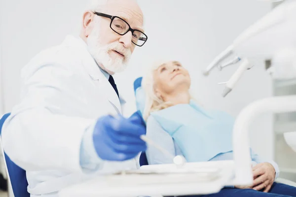 Calma dentista masculino poner de nuevo espejo dental — Foto de Stock