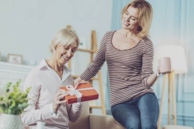 Bir hediye tutarak ve kızıyla birlikte oturan yaşlı kadın