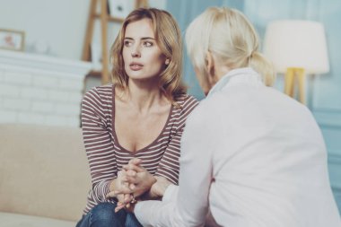 Annesiyle birlikte oturan ve üzgün genç kadın