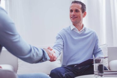 Müvekkilinin elini sıkarken iyimser psikolog