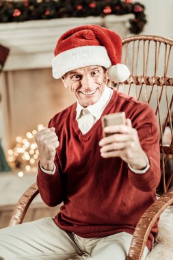 Oturma ve sevindirici mutlu adam hayran.