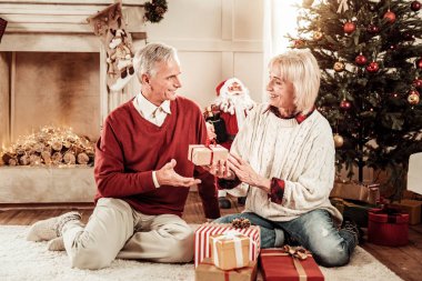 Gülümseyen ve yakın oturan mutlu güzel çift sunar.