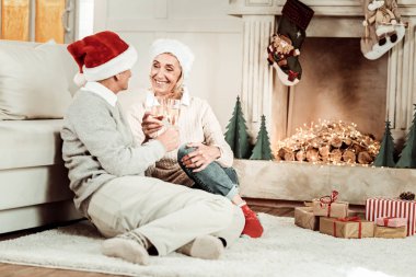 Oturma ve gözlük tutan memnun yaşlı çift.