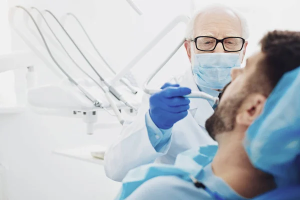 Dentista masculino concentrado que retira la caries dental — Foto de Stock