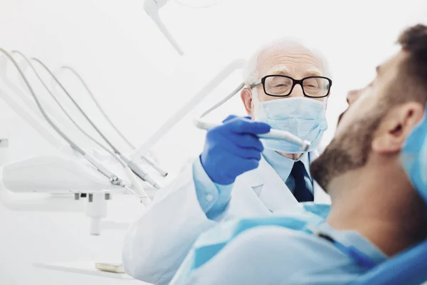 Dentista masculino experimentado reemplazando el diente — Foto de Stock