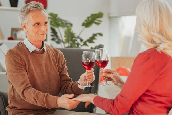 Щасливий літній чоловік і дружина п'ють вино і тримають руки — стокове фото