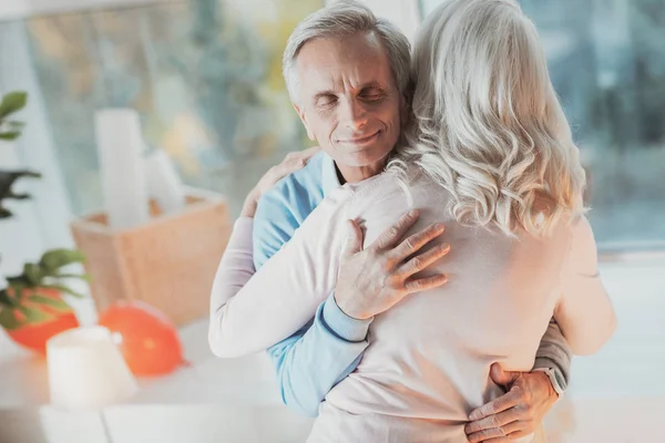 Веселый пожилой муж обнимает жену — стоковое фото
