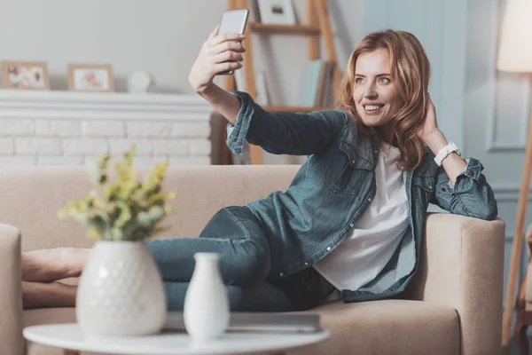 Mulher atraente alegre olhando para a câmera do smartphone — Fotografia de Stock