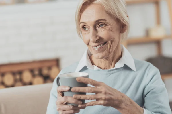 Šťastný starší žena držící šálek čaje — Stock fotografie