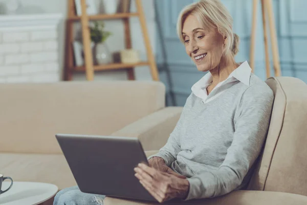 Ältere Dame sitzt mit Laptop — Stockfoto