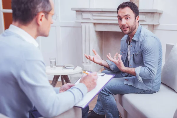 Pria berjanggut yang bersemangat menjelaskan masalahnya kepada psikiater — Stok Foto