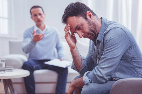 Devastated bearded man touching his forehead during psychological therapy — Stock Photo, Image