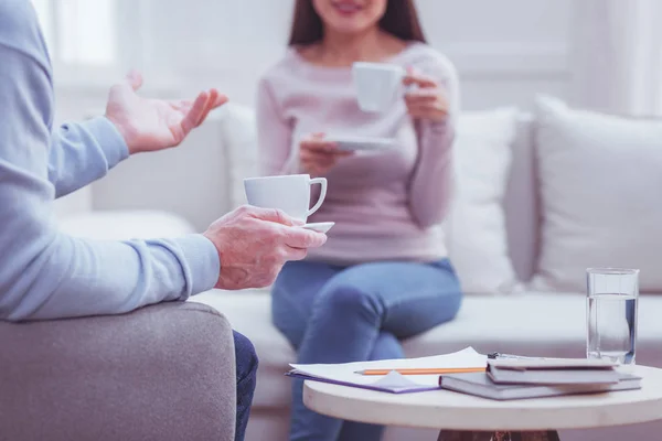 Experienced psychologist drinking coffee with his client — Stock Photo, Image