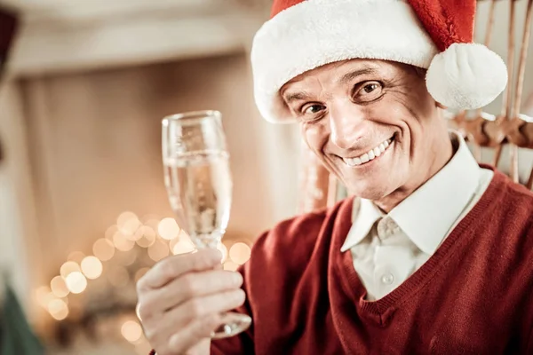 Feliz hombre mayor sonriendo y sosteniendo un vaso . — Foto de Stock