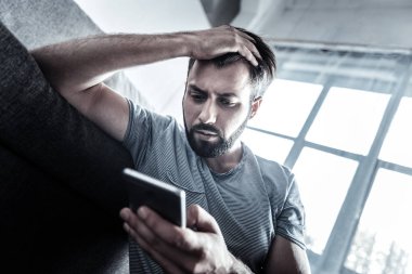 Ciddi genç adam onun aygıtı arıyorum