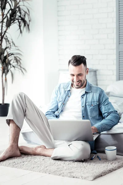 Attractive freelancer keeping smile on his face — Stock Photo, Image