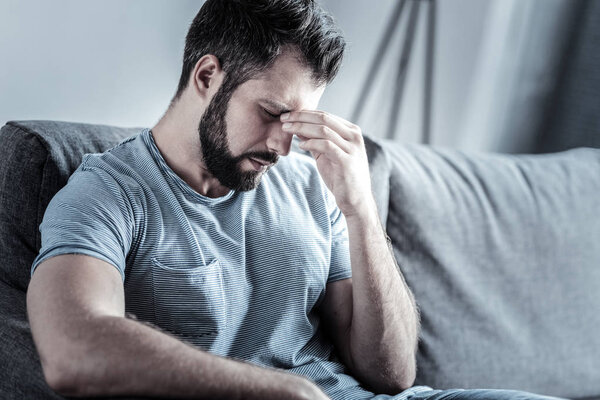 Sad bearded male bowing his head