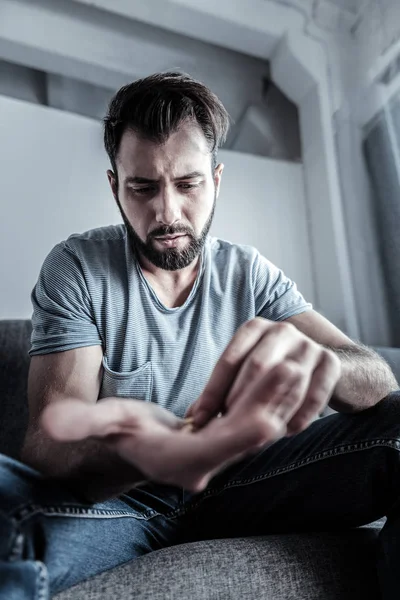 Irritado barbudo masculino olhando para a palma da mão — Fotografia de Stock