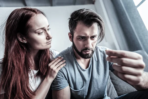 Serious brunette staring at his fingers