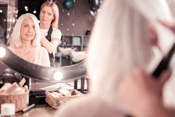 Attentive blonde woman looking at her image — Stock Photo, Image