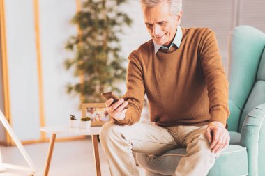 Emekli adam aile fotoğrafları izlerken gülümsüyor