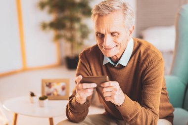 Yaşlı iletilerini okuyor gülümseyen adam emekli