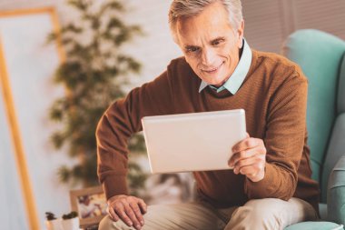 Saygılı adam oturma odasında elektronik kitap okuma