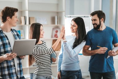 Koyu renk saçlı kadın onun meslektaşı yüksek beş veren