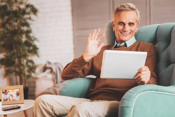 Smiling man feeling happy chatting online with friends