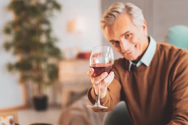 Homem segurando copo de vinho tinto francês em suas mãos — Fotografia de Stock