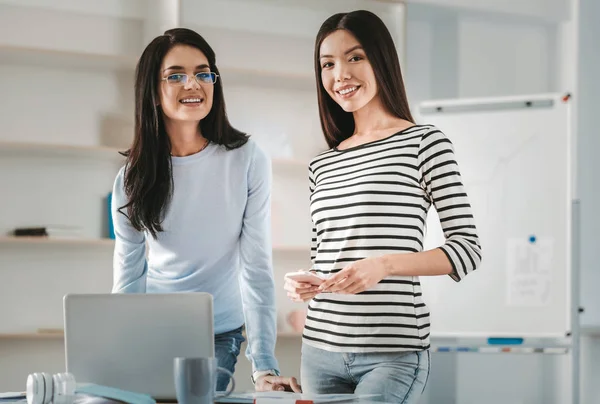 Mujer sonriente apelando unirse a su hermana en la oficina —  Fotos de Stock