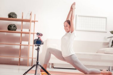 Sportif Bayan. Bir egzersiz gösterilen süre çevrimiçi bir eğitim veren genç çekici eğitmeni