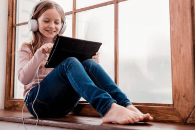 Gülümseyen kız tablet üzerinde oynama