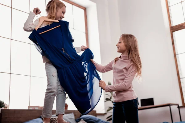 Angenehme Kinder probieren ein Kleid — Stockfoto