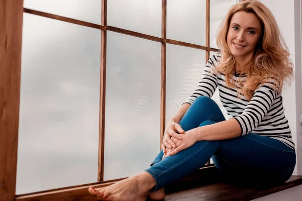 Nette Dame sitzt auf der Fensterbank — Stockfoto